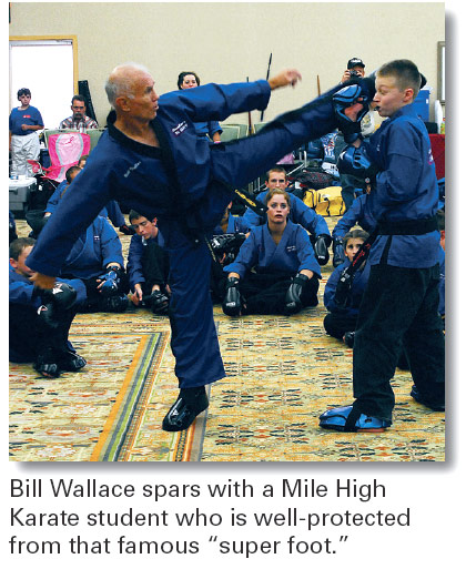 Bill Wallace spars with a Mile High Karate student who is well-protected from that famous “super foot.”